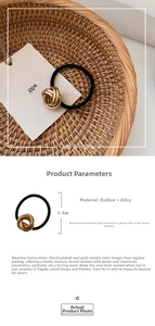 Detail of minimalist hair tie with gold interwoven metal buckle and black elastic band