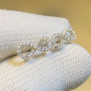 Silver bow-shaped earrings with four interlocking circles inlaid with white zircons