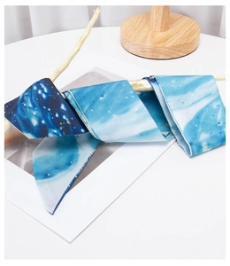 Artistic blue floral long scarf with galaxy patterns tied on a rustic wood branch