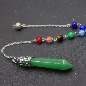 Close-up of a green crystal hexagonal pendulum necklace with colorful chakra beads on chain