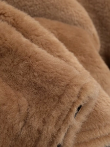Close-up of soft brown faux fur texture on a high neck jacket with fluffy detail