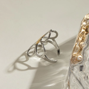 Two-tone stainless steel open ring with cutout flower design and golden center accent