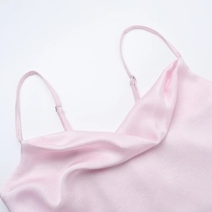 Detail of light pink satin dress with adjustable spaghetti straps and silky texture