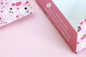 Macro detail of pink cotton silver polishing cloth packaging with star and flower prints