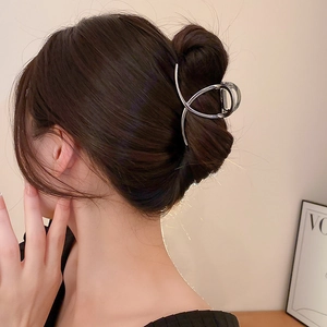 Close-up of minimalist silver irregular geometric metal hair claw clip worn by a model