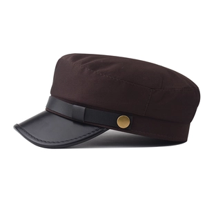 Detail of dark brown military cap featuring black leather brim and golden metal buckle