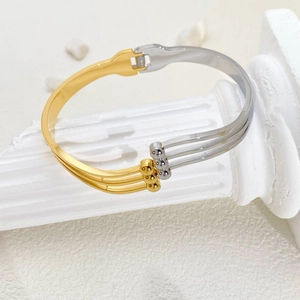 Detail of two-tone gold and silver stainless steel cuff with triple-layered metal bands