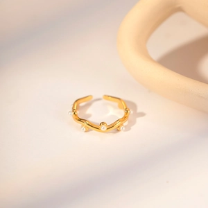 French vintage style wavy gold titanium ring with pearls on elegant ceramic stand