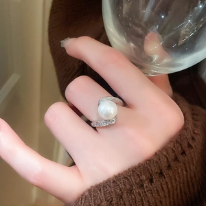 Gros plan d'une bague serpent plaquée or avec une grande perle blanche et des zircons fins