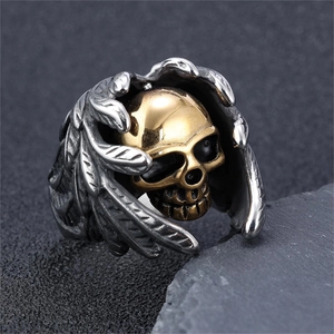 Détail macro d'une bague gothique avec crâne doré et ailes en argent oxydé
