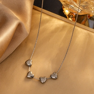 Elegant silver heart pendant necklace with four charms on premium silk gold background