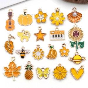 Assorted yellow and orange enamel metal charms with floral and novelty shapes for DIY jewelry