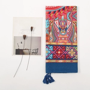 Close-up of vibrant bohemian floral print shawl with dark blue tassel ornaments