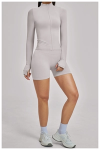 Detail eines schmal geschnittenen Yoga-Sets mit Stehkragenjacke und Daumenlochbündchen
