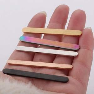 Hand holding five DIY stainless steel ring blanks in gold, rainbow, silver, rose gold and black