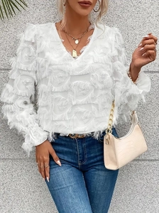 White V-neck fringe blouse with ruffle sleeves paired with blue jeans and accessories