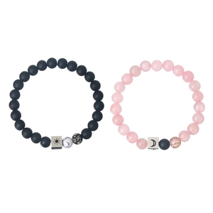 Macro view of sun and moon engraved metal beads on matching couple beaded bracelets
