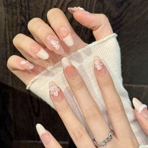 Handmade almond press-on nails with pink gradient, 3D floral relief, and pearl accents