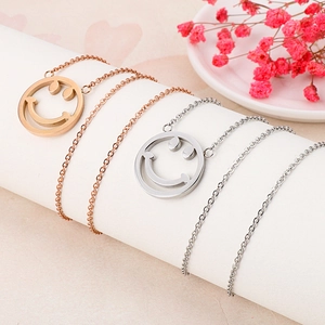 Gros plan de colliers pendentifs sourires creux or et argent sur des supports d'affichage