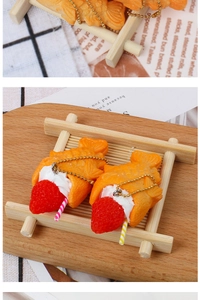 Macro shot of realistic Taiyaki keychain with cream and strawberry filling on wooden tray