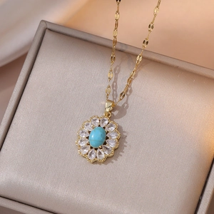 Detail shot of golden flower pendant with blue stone and white zircon on silk cushion
