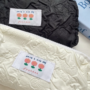 Close-up of quilted bubble fabric and 'Have a nice day' floral embroidery on pencil case