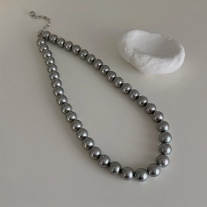 Macro detail of high-quality grey pearl necklace with silver lobster clasp and extension chain