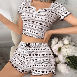 Close-up of ribbed knit pajamas with heart prints, lace neckline and ribbon bow detail
