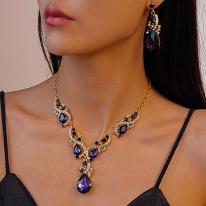 Close-up of elegant purple teardrop crystal necklace and matching earrings on a model