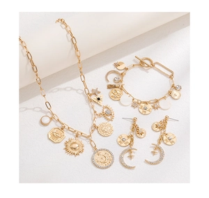 Detailed view of gold celestial jewelry set with star, moon and eye motifs on props