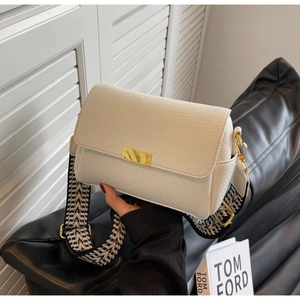 Détail du sac à bandoulière blanc texturé avec sangle géométrique et boucles dorées