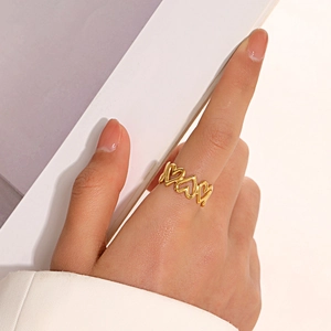 Bague ouverte coeur évidé en acier plaqué or 18K portée par un mannequin style moderne