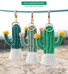 Detail of handmade woven cactus keychains with cotton tassels and gold metal hooks