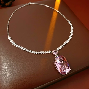 Macro shot of sparkling pink rectangular zircon pendant on silver link chain necklace