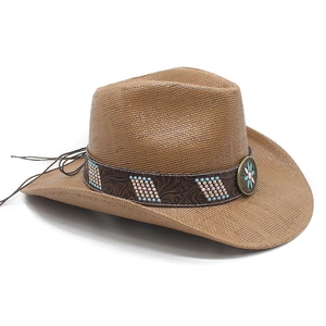 Detail of brown woven cowboy hat with ethnic beads and a vintage floral metal badge