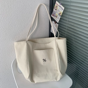Detail shot of heavy-duty cream canvas tote bag with black percentage symbol and clear texture
