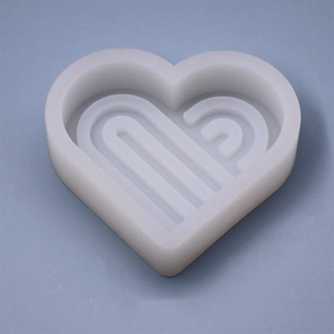 Macro shot of white silicone heart mold with geometric lines for DIY candle making