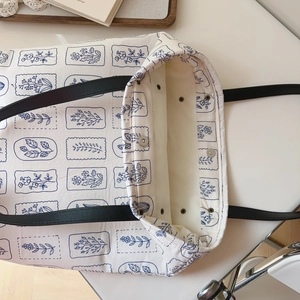 Detail view of canvas tote bag with floral print showing magnetic snap closure and interior