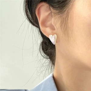 Irregular heart-shaped earrings with mermaid pearl effect on a model's ear