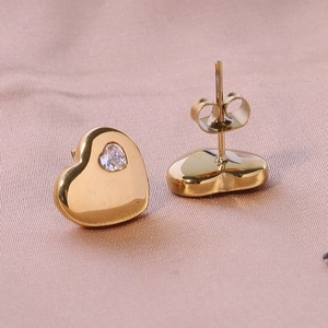 Detail of 12mm 18K gold heart stud earrings with sparkling cubic zirconia on satin fabric