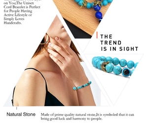 Detail of beaded bracelet with turquoise stones, gold crown charm and evil eye bead