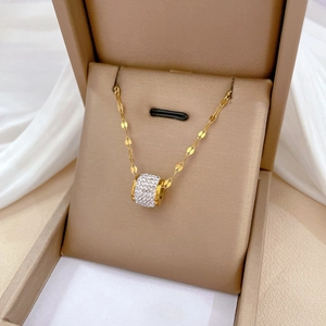 Detail of gold titanium cylinder pendant with crystals in a luxury jewelry box