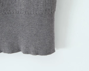 Close-up of gray knit fabric showing detailed ribbed cuff and fine stitching texture