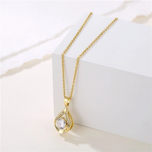 Elegant gold-tone water drop pendant necklace with zircon stone on a white stand
