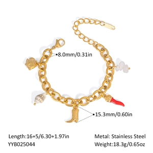 Macro detail of stainless steel charm bracelet with fish shell and chili pendants