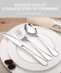 Detail of 3-piece stainless steel cutlery set on a Baroque plate with pine cones decoration
