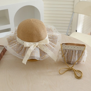 Detail of straw hat and matching bag with lace bow and dot mesh for girls' summer outfit