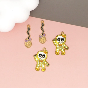 Detailed view of Halloween broom and skeleton enamel charms for DIY jewelry making