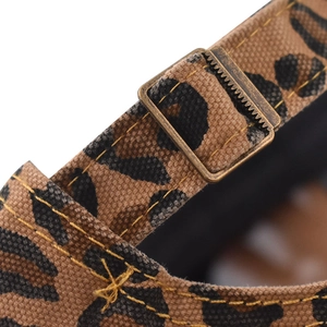 Close-up of leopard print canvas fabric with vintage metal buckle and yellow stitching