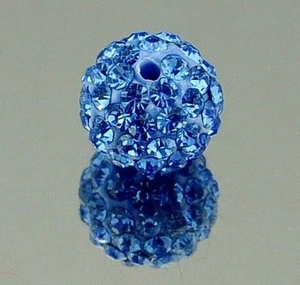 Close-up of blue Shamballa clay bead with sparkling rhinestones for DIY jewelry making